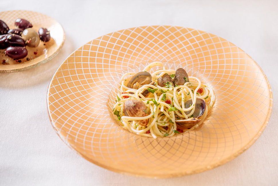 pasta plate bowl with a large rim and patter in gold with a matching side plate and mussels pasta