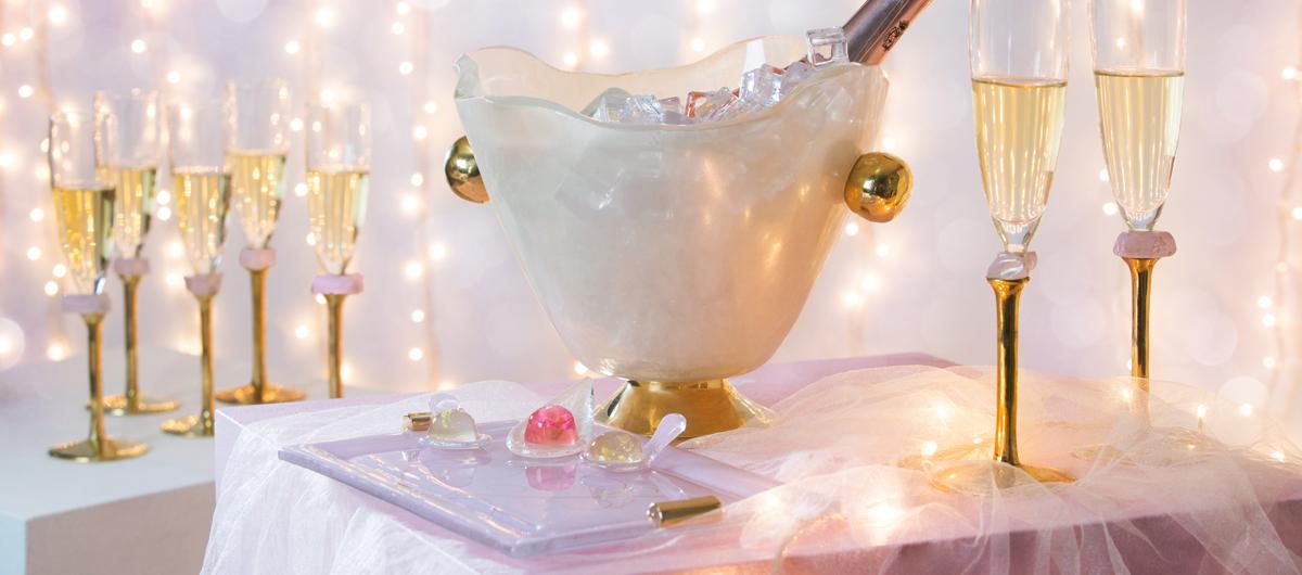 party plates elegant table setting in champagne colour and soft shell pink with ice bucket, champagne flutes and charger plates with jello shots with flowers
