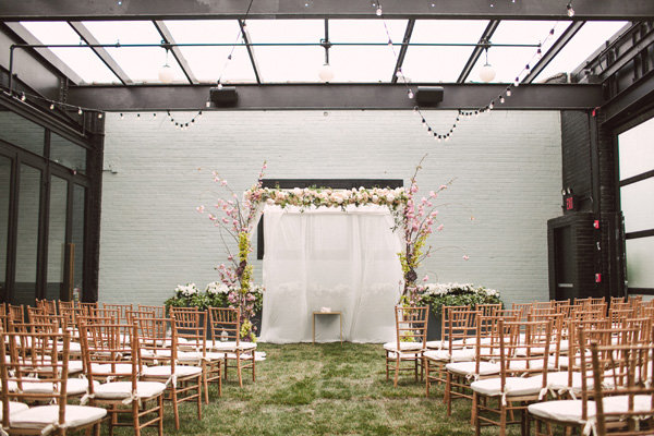 Wedding ideas - indoor wedding setting, wooden chairs, fake grass, glass rooftop