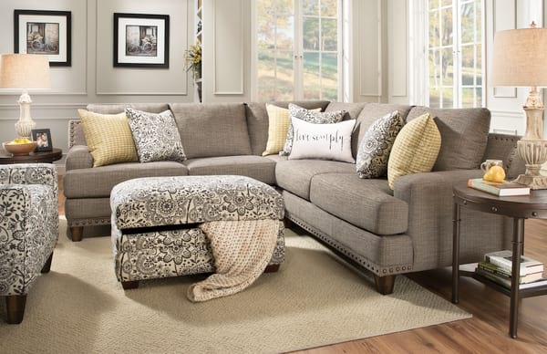 Beige grey living room with patterned ottoman and pillows