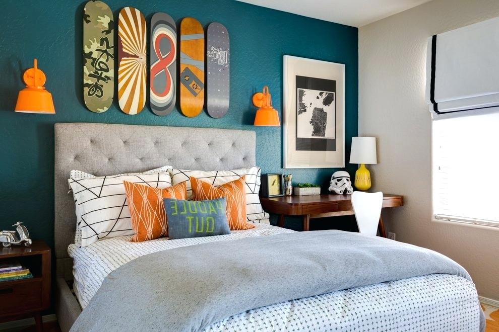 colourful bedroom with grey bed and blue accent wall with skateboards 