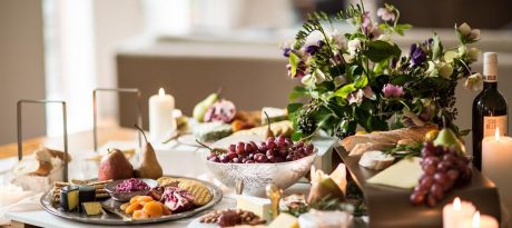 Beautiful table with fruits, cheese and crackers with glass designer tableware